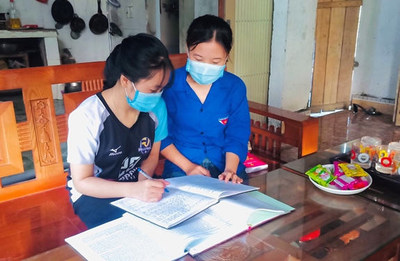 Đoàn viên Nguyễn Thị Mai Hoa hướng dẫn em Vi Thị Thảo ôn bài.
